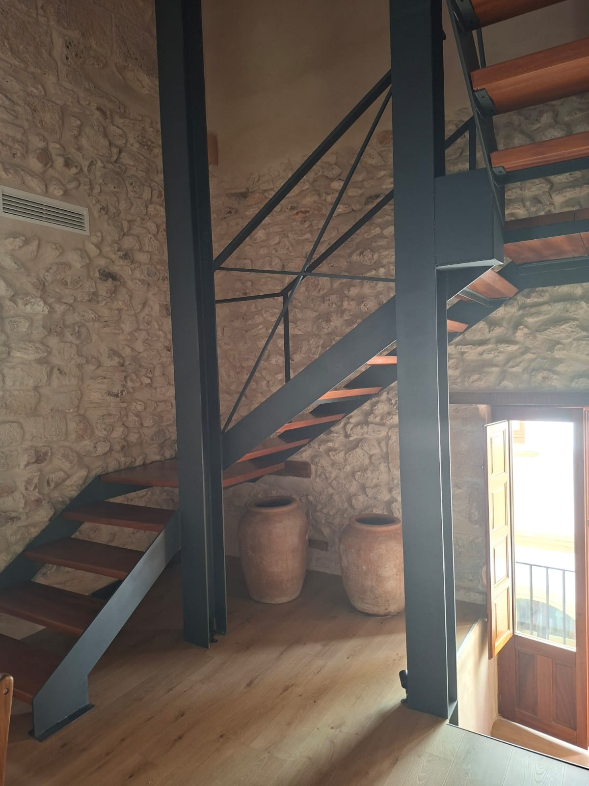 Escalera metálica y pasarela interior en vivienda histórica