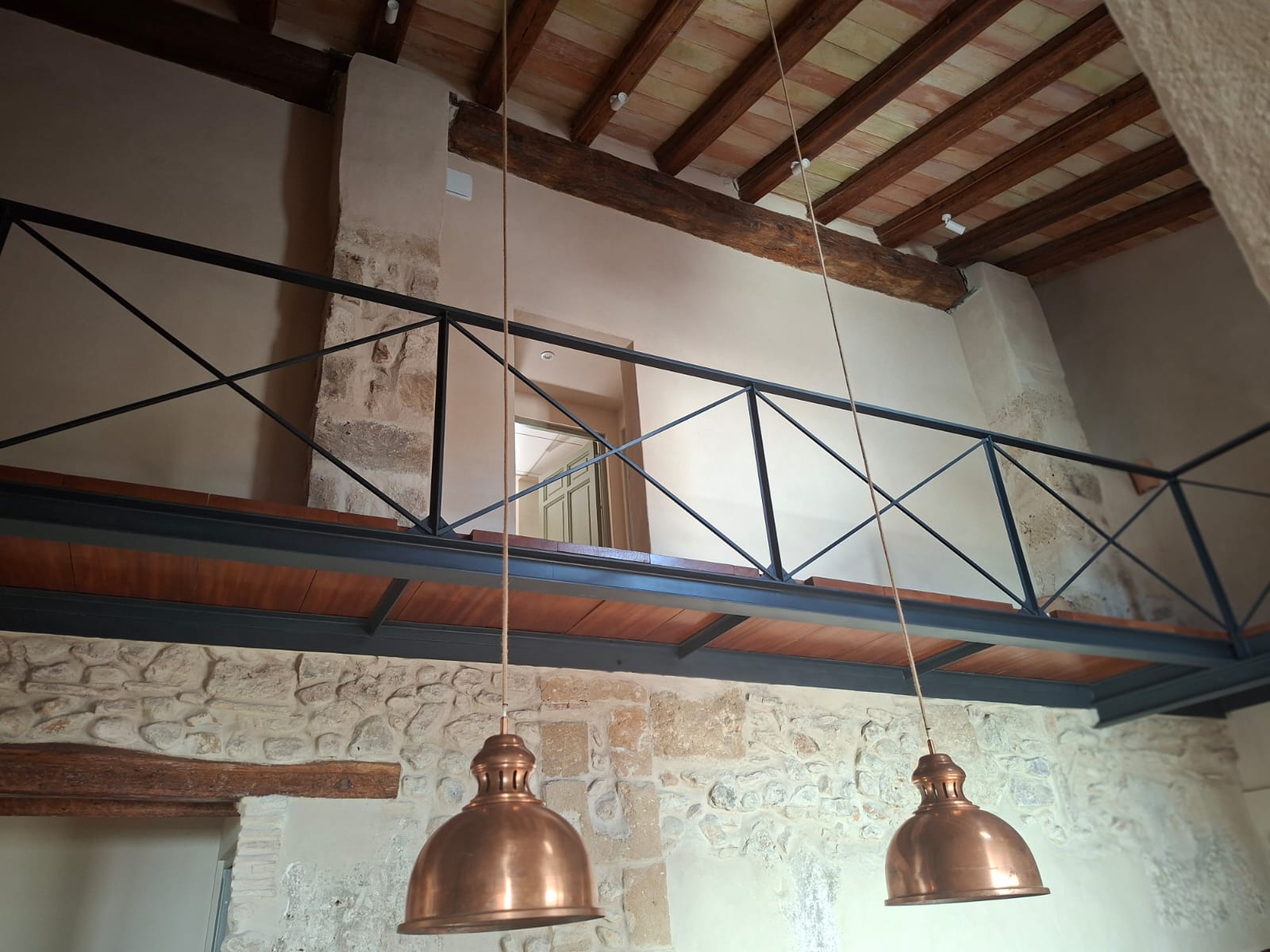 Escalera metálica y pasarela interior en vivienda histórica
